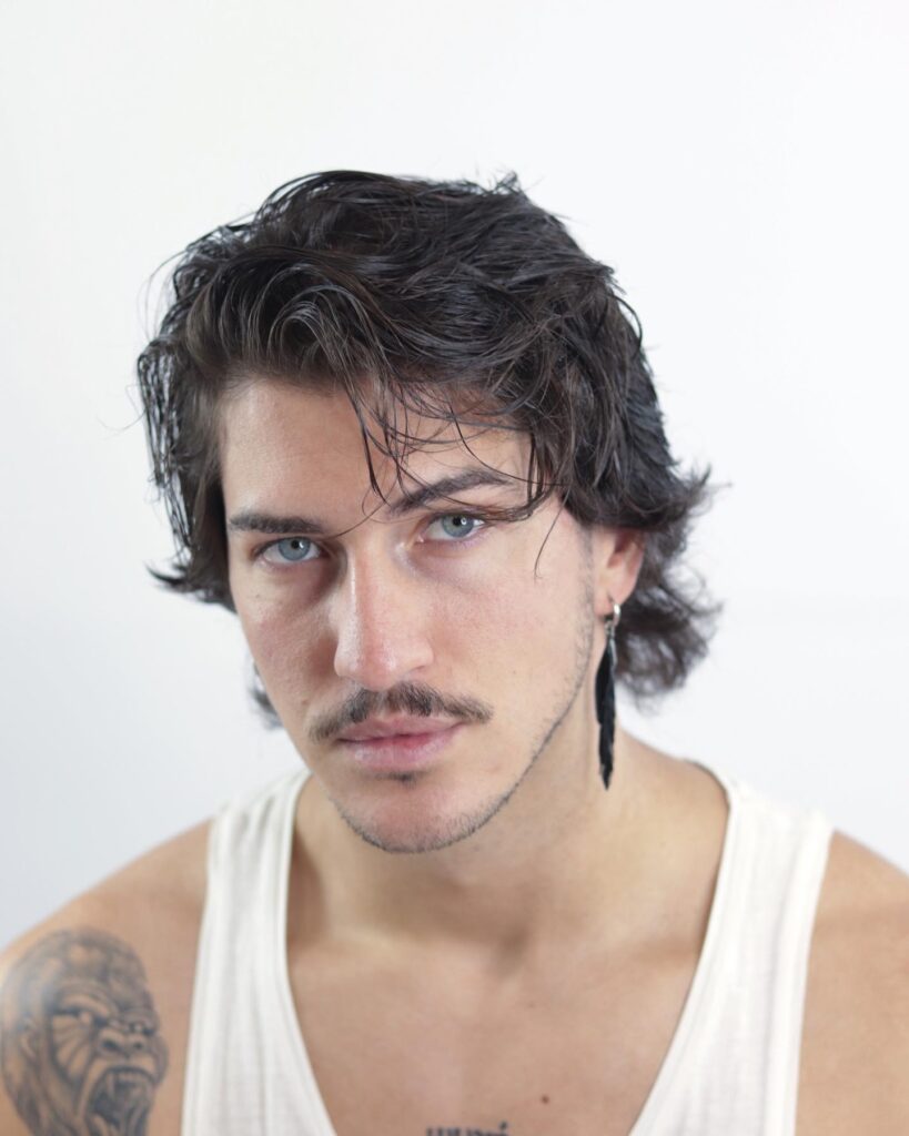 Capelli medi mossi con riga naturale e baffi, vista frontale